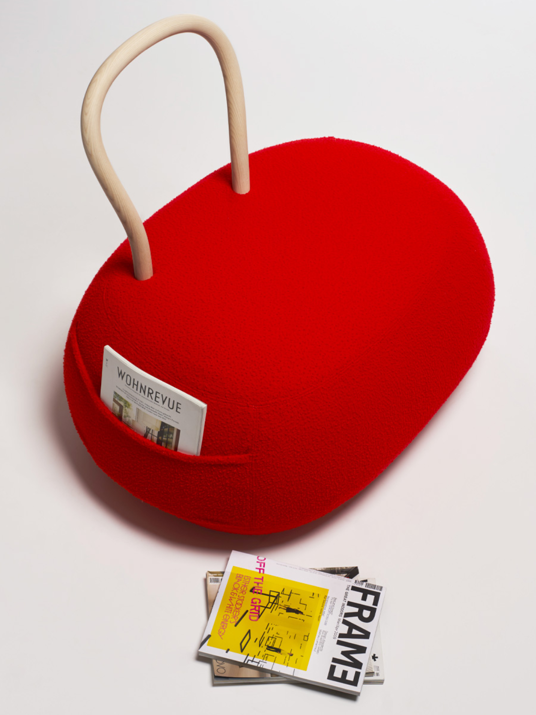 A red chair with a pocket and a looped wooden back rest from Opinion Ciatti