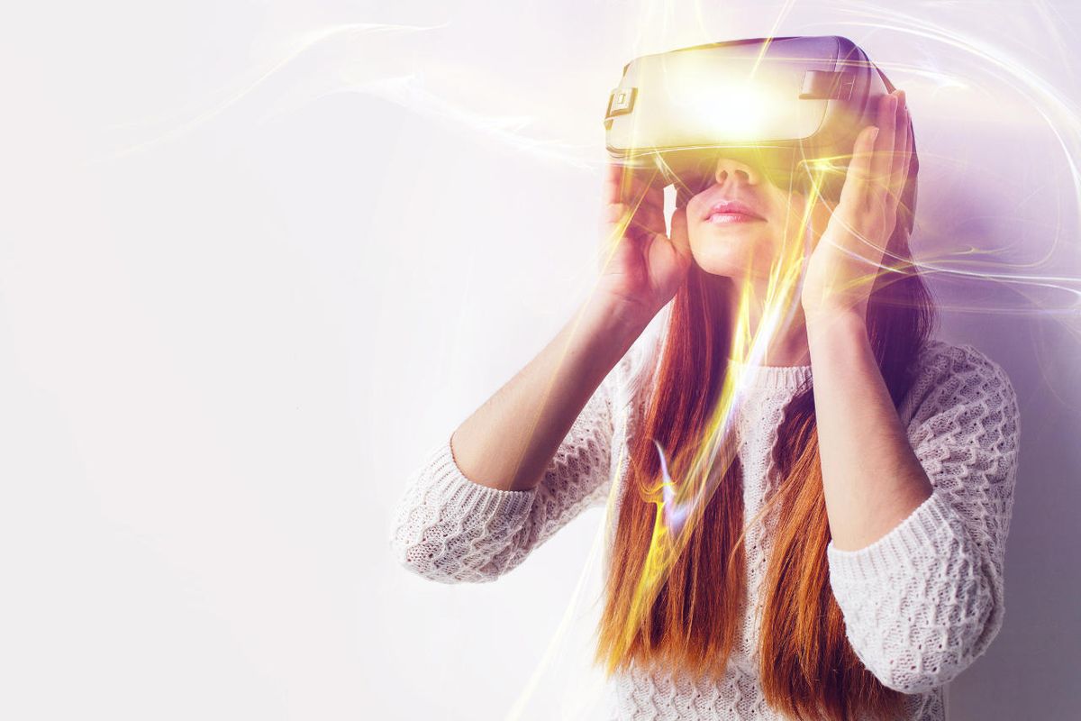 Young woman looks through virtual reality goggles.