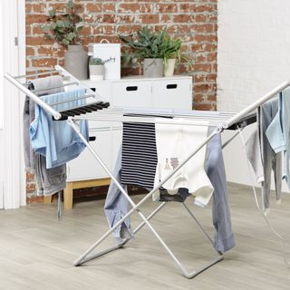 A winged heated clothes airer hung with blue and white washing