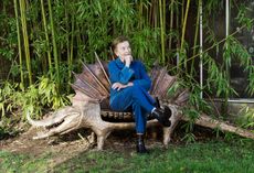 Claude Lalanne in the garden of her Fontainebleu home with her 2012 bronze La femme du crocodile sculpture