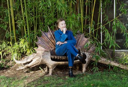 Claude Lalanne in the garden of her Fontainebleu home with her 2012 bronze La femme du crocodile sculpture