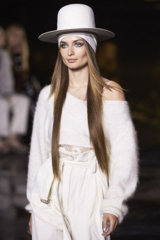 A model walks the runway dressed all in white.