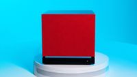 A Steam Machine with a red faceplate on a blue background, in the center of the frame