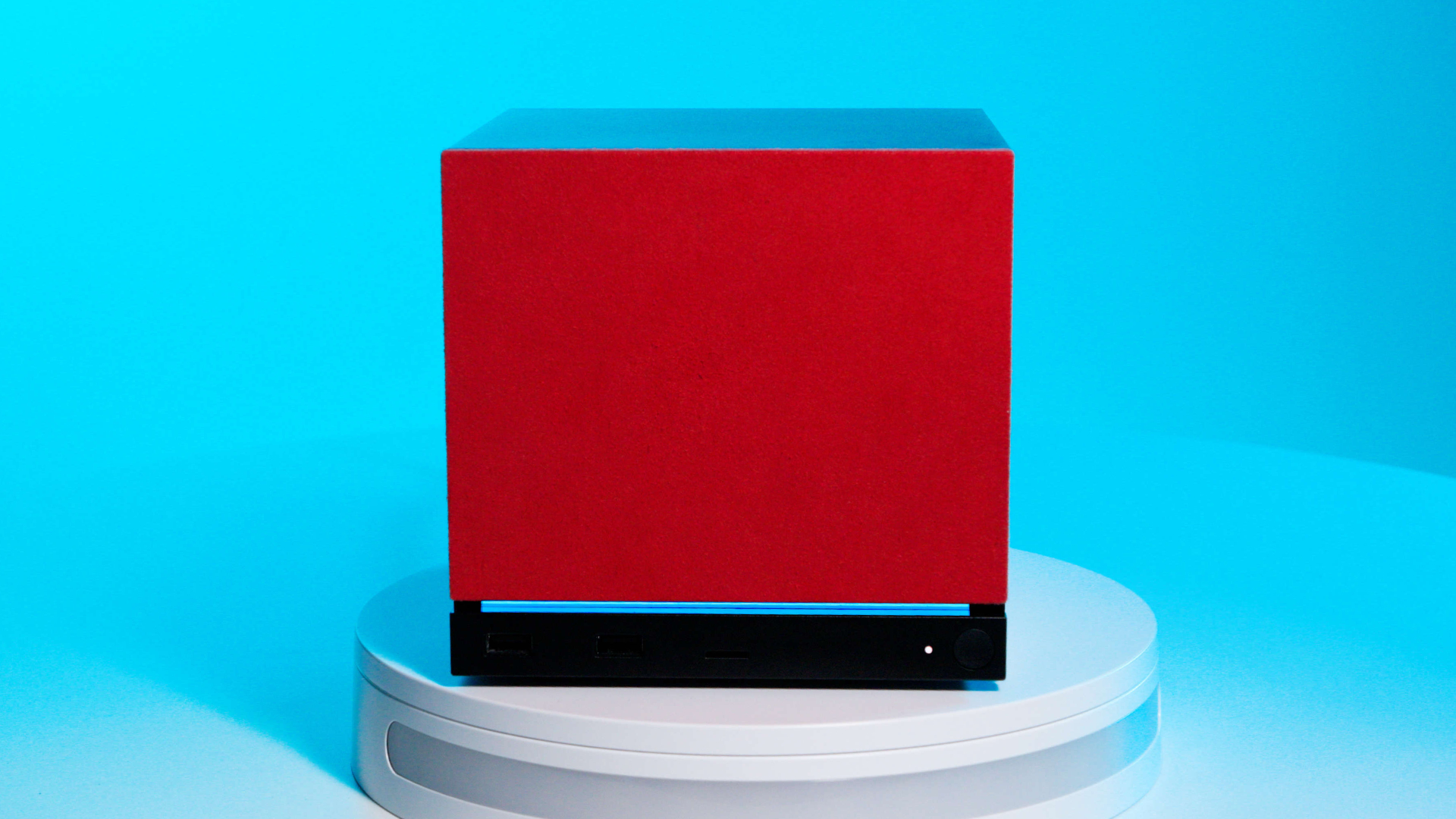 A Steam Machine with a red faceplate on a blue background, in the center of the frame