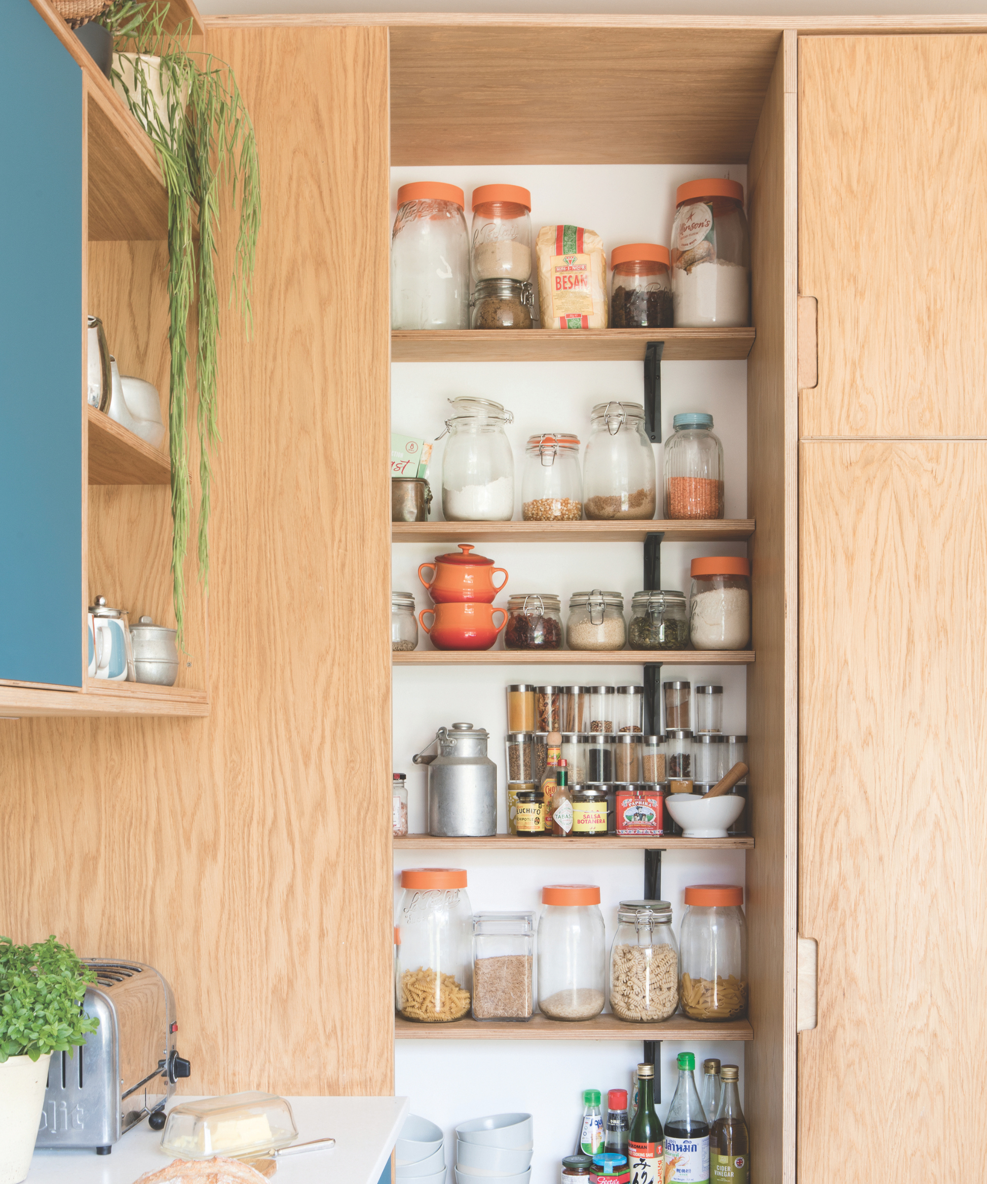 Kitchen with glass jars inside of a wooden cupboard