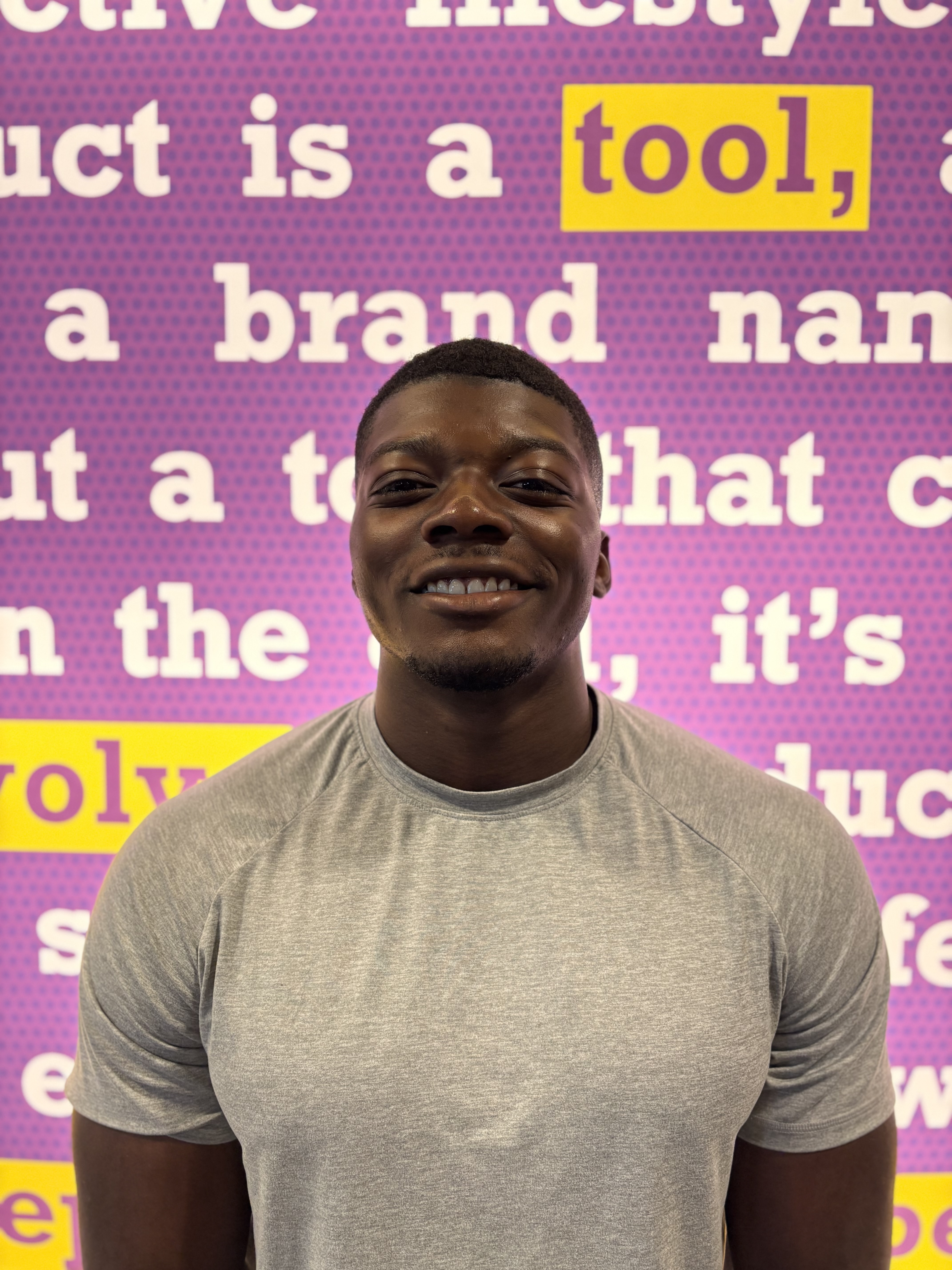 Head and shoulders of smiling man looking at camera wearing gray T-shirt