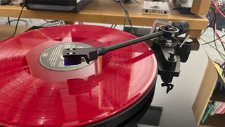 Dual CS 618Q turntable with tone arm lifted above pink vinyl