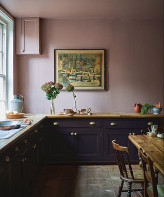 kitchen with black kitchen cabinets, earthy pink walls and wooden countertops