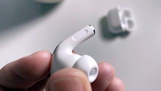 A person holding one of the AirPods Pro buds in their fingers.