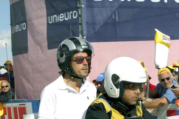 Formula 1 star Fernando Alonso arrives at the summit via motorcycle.