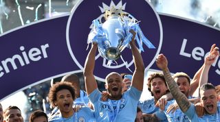 Manchester City's Belgian defender Vincent Kompany (C) holds up the Premier League trophy after their 4-1 victory in the English Premier League football match between Brighton and Hove Albion and Manchester City at the American Express Community Stadium in Brighton, southern England on May 12, 2019. - Manchester City held off a titanic challenge from Liverpool to become the first side in a decade to retain the Premier League on Sunday by coming from behind to beat Brighton 4-1 on Sunday. (Photo by Glyn KIRK / AFP) / RESTRICTED TO EDITORIAL USE. No use with unauthorized audio, video, data, fixture lists, club/league logos or 'live' services. Online in-match use limited to 120 images. An additional 40 images may be used in extra time. No video emulation. Social media in-match use limited to 120 images. An additional 40 images may be used in extra time. No use in betting publications, games or single club/league/player publications. / (Photo credit should read GLYN KIRK/AFP via Getty Images)