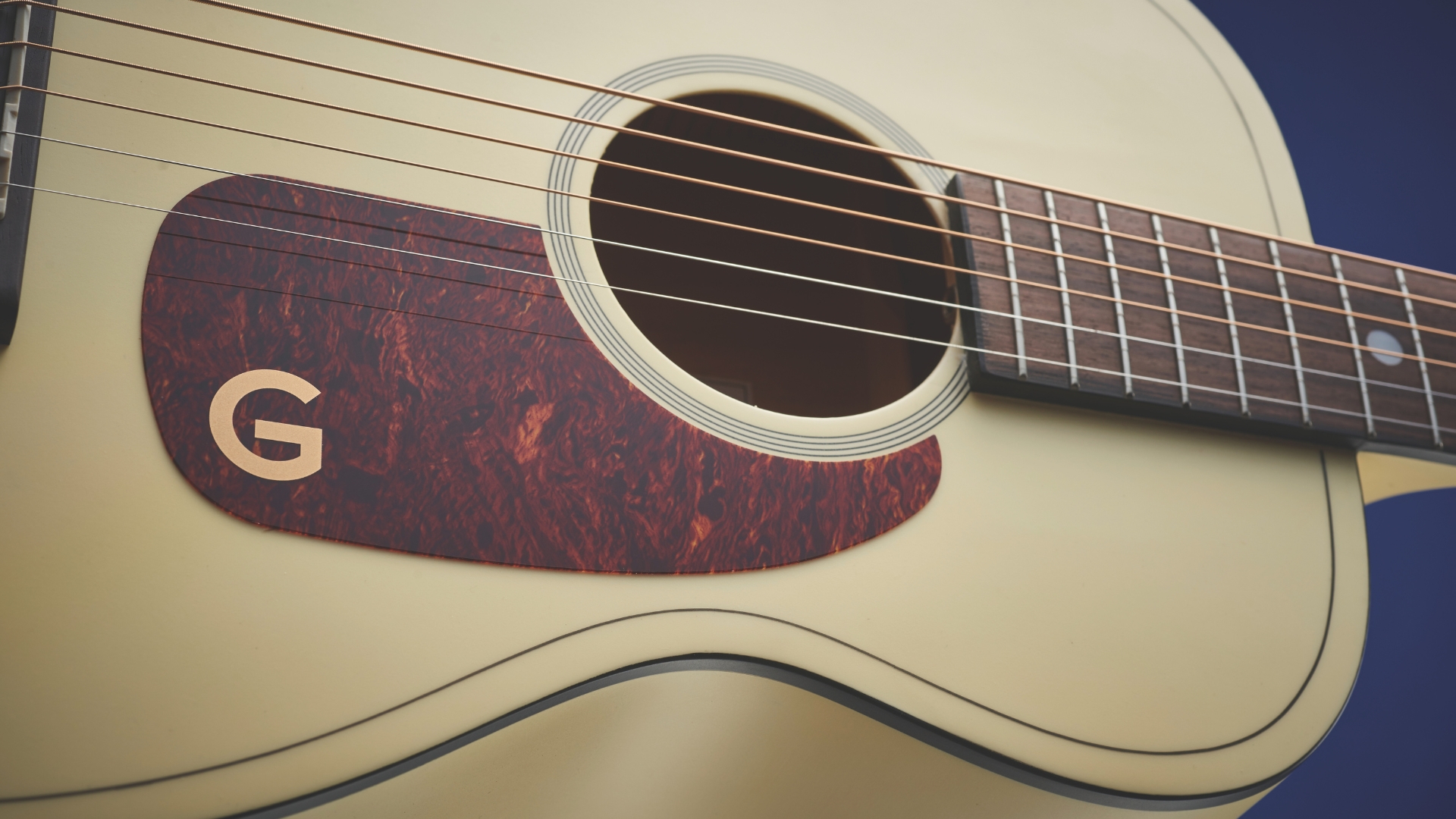 Close up of the body and pickguard on a Gretsch G9500 Jim Dandy acoustic guitar