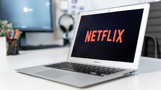 Netflix logo on a MacBook Air in a home office setting