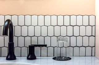 White tiles with black grouting and peach walls