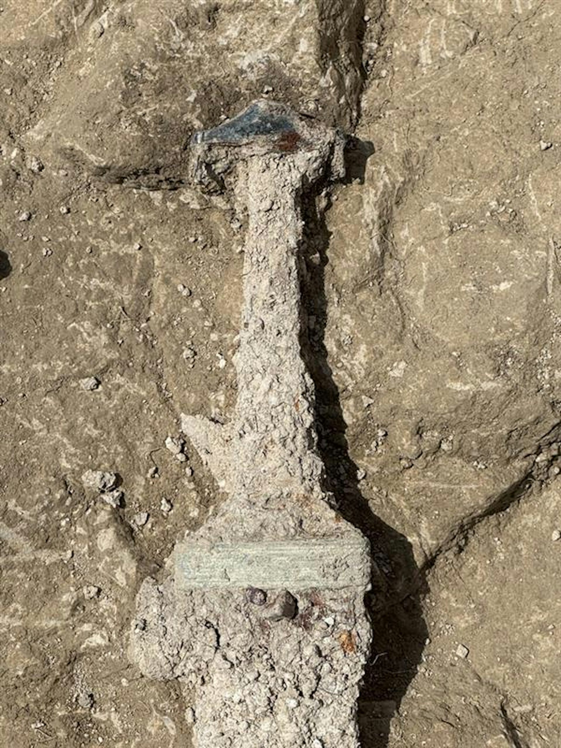 A corroded metal sword in the dirt