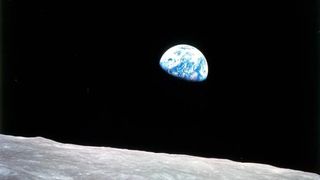 A half Earth rising above the moon