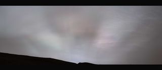 streaks of light stretch across a cloudy sky on mars
