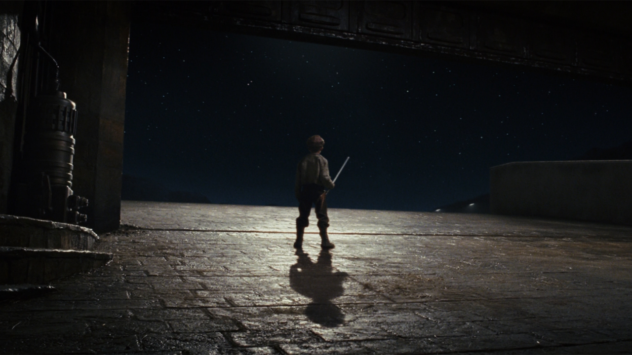 Broom Boy looking at the sky and holding his broom in Star Wars: The Last Jedi