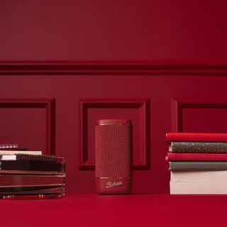 red bluetooth speaker and books and red wall