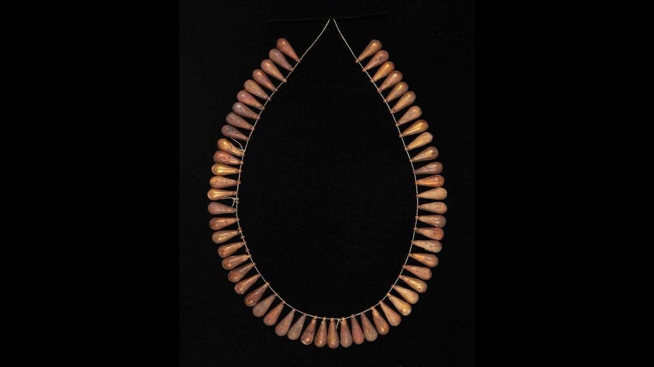 Gold necklace made out of numerous golden petals strung together.