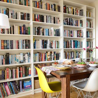 book shelves table with chairs and wooden flooring