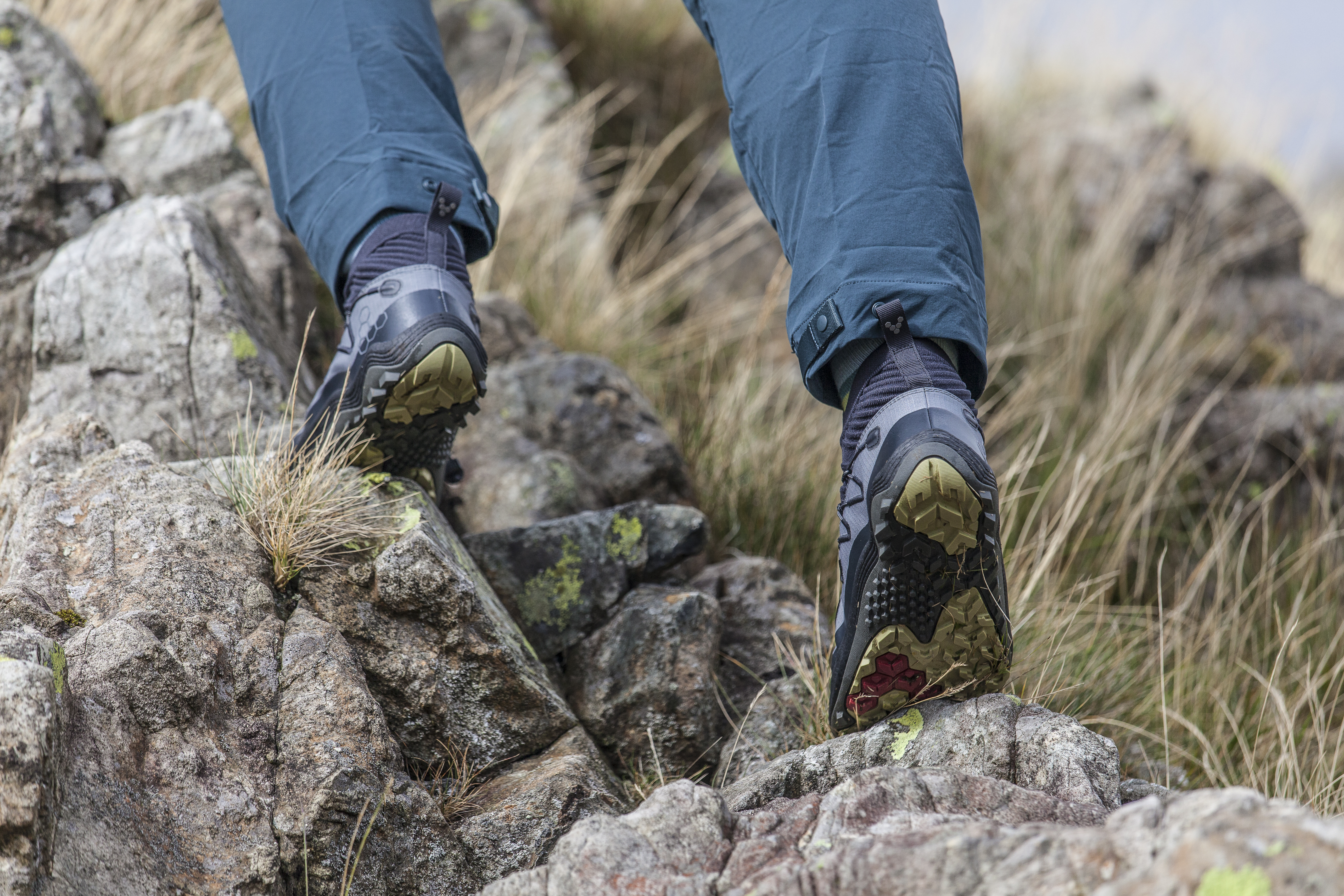 Woman wearing Vivobarefoot Primus Flow Mid hiking boots and scrambling in them