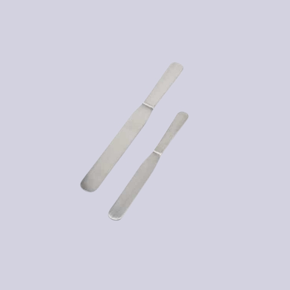 Two chrome palette knives with a minimal design, one longer, one shorter, lay next to each other against a lilac background.