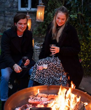 People sat around a fire pit at night