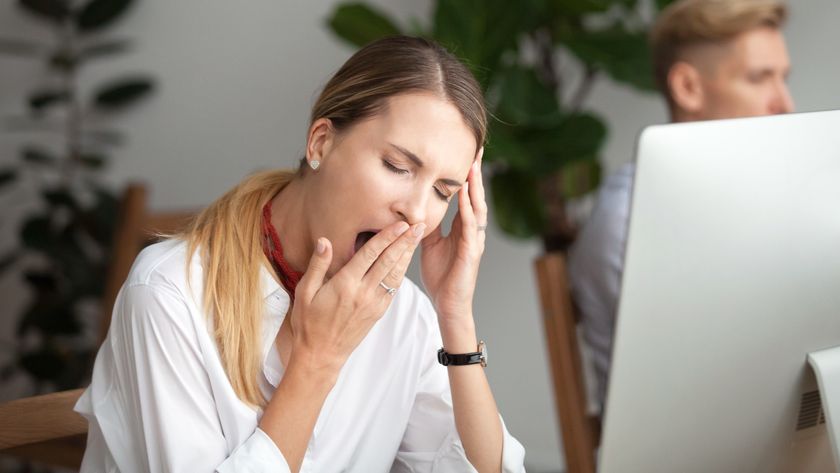 woman yawning at work in front of computer