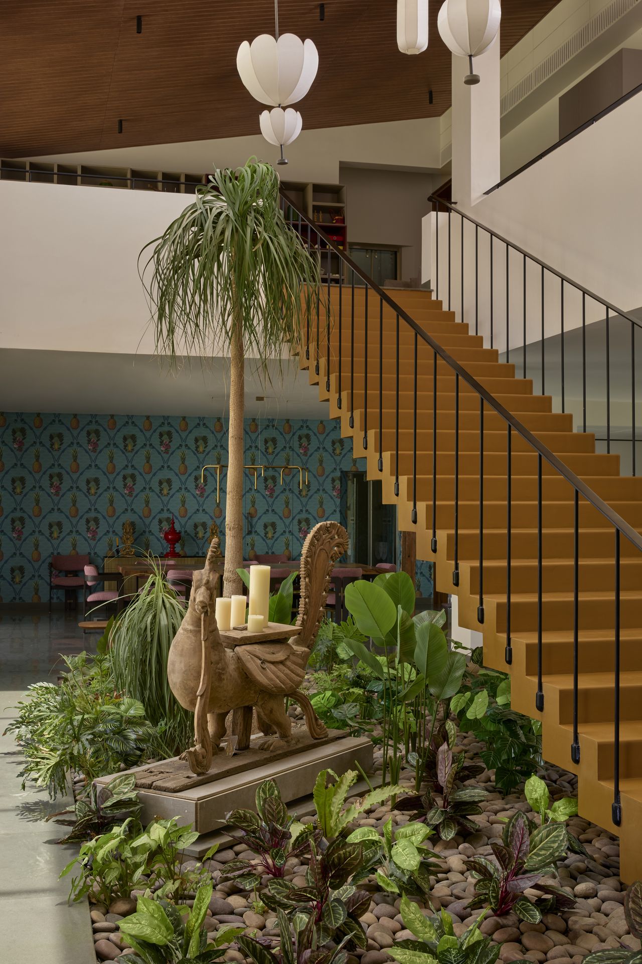 An orange staircase, with a green pocket next to the stairs, and a sculpture placed atop
