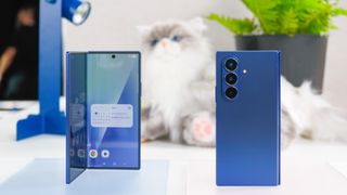 Two blue Samsung Galaxy Z Fold 7 devices with a stuffed cat behind them