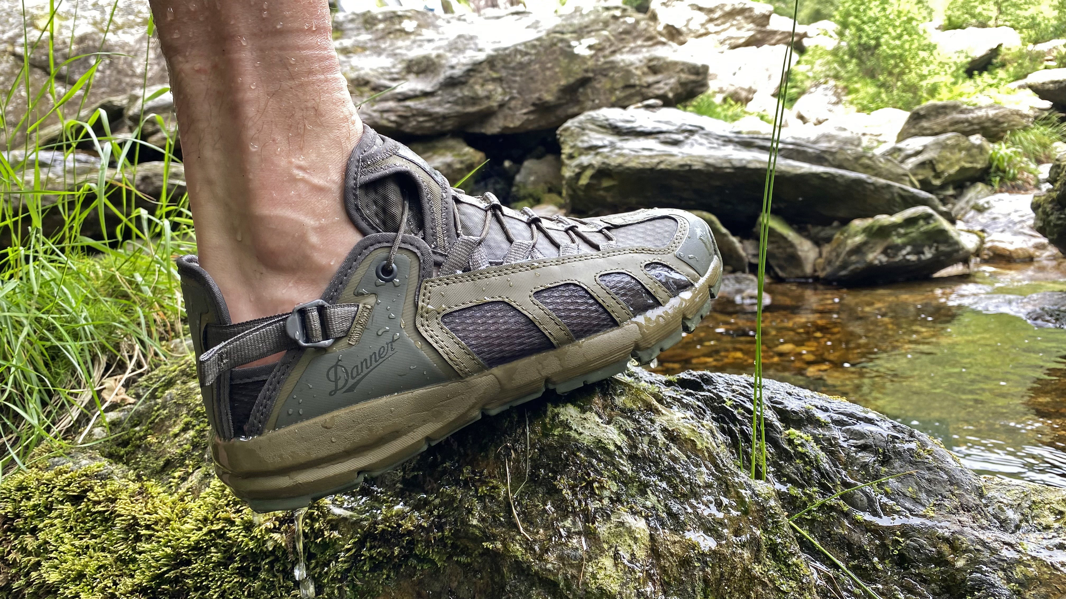 A hiker rock hopping in the Danner Fullbore Sandals