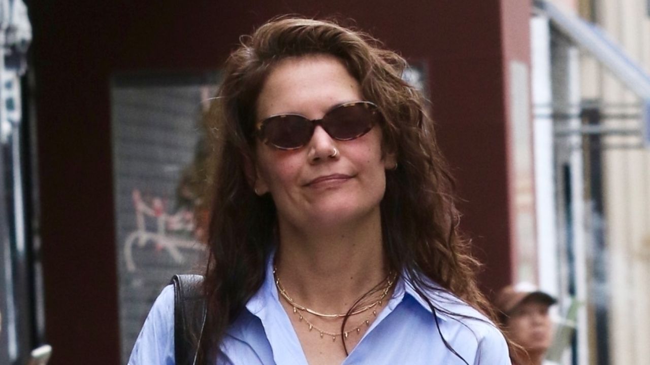 Katie Holmes walks in New York City on April 17 wearing a button down shirt and gold necklaces