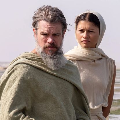 matt damon as odysseus and zendaya as athena standing on a beach in the odyssey