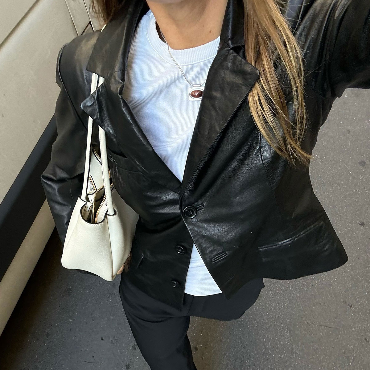 @annelauremais outfit selfie in leather blazer, white ribbed tee, and cream shoulder bag