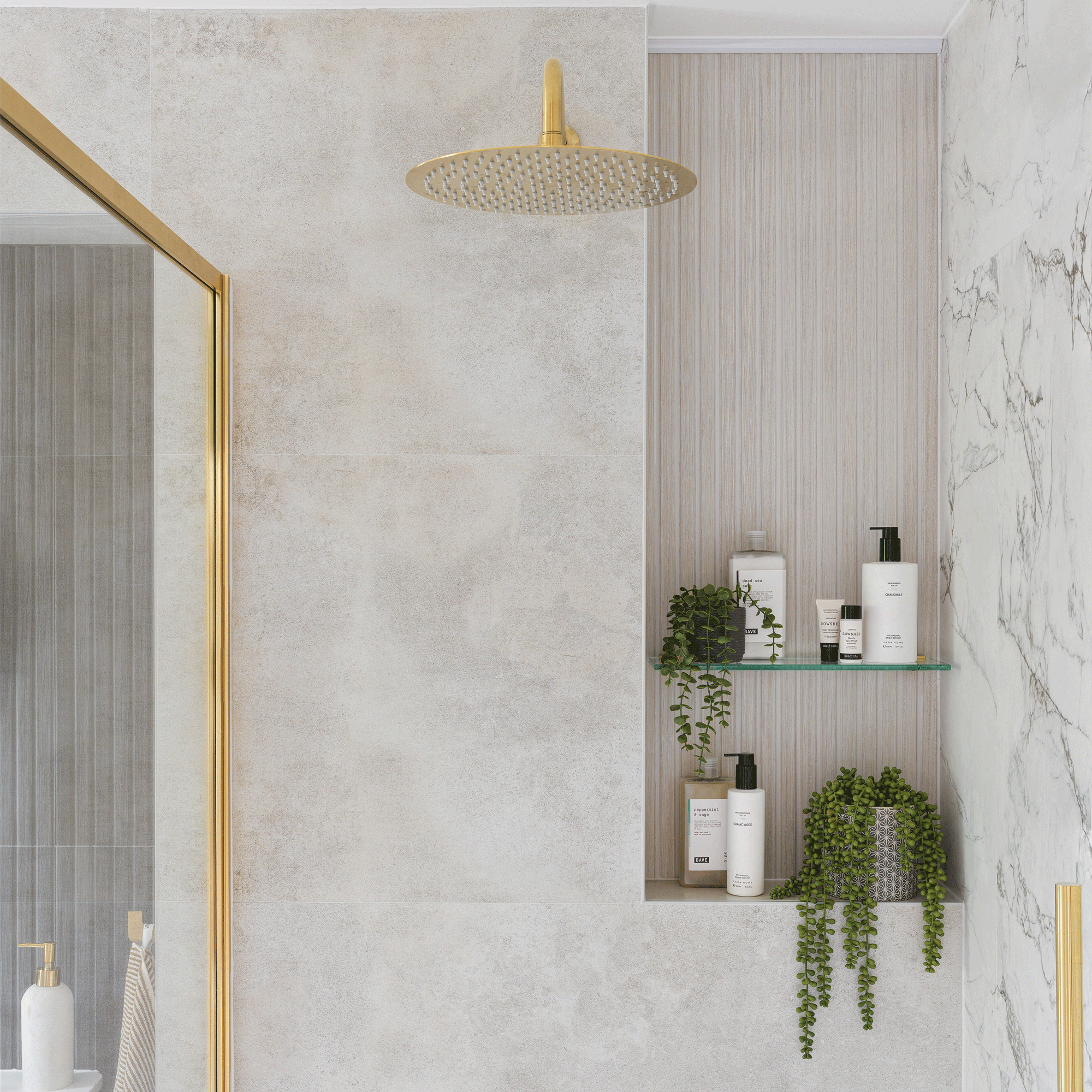 a large walk-in shower with brass showerhead and screen trim and marble walls