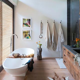 bathroom with white bath tub reclaimed timber flooring and antique pine vanity unit