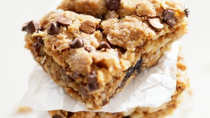 Chocolate chip granola bars stacked with baking paper 