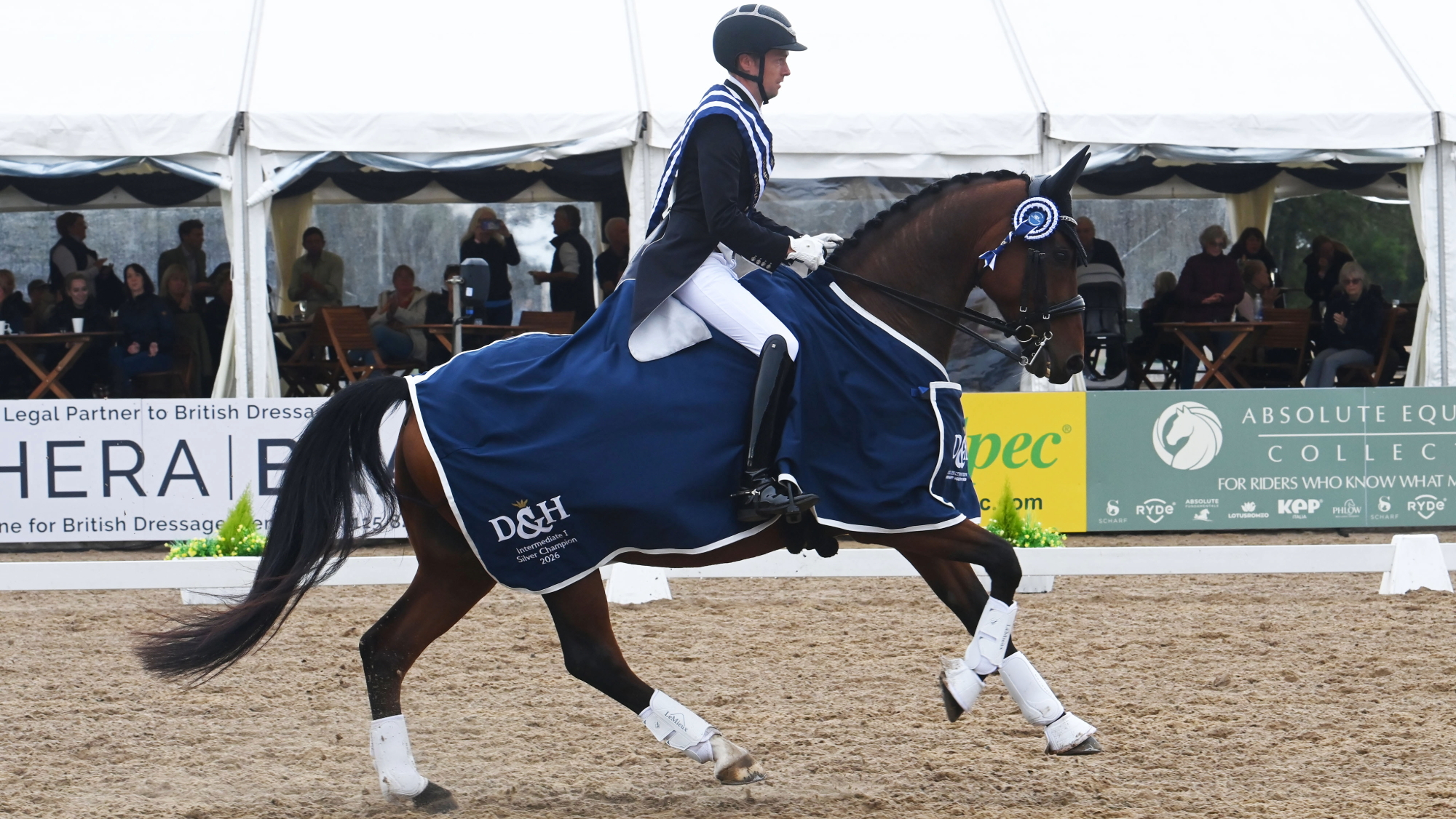 Michael Whippey rides Genson Blue in canter, wearing the D&amp;amp;H Intermediate I Silver Champion 2026 rug, at the LeMieux National Dressage Championships.