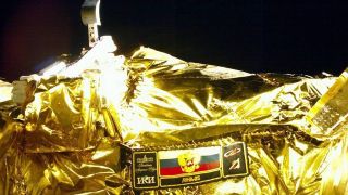 a close up of the body of a spacecraft wrapped in gold foil in space