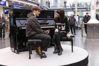 Ellis chats to Claudia before playing Chopin at Manchester Piccadilly station.