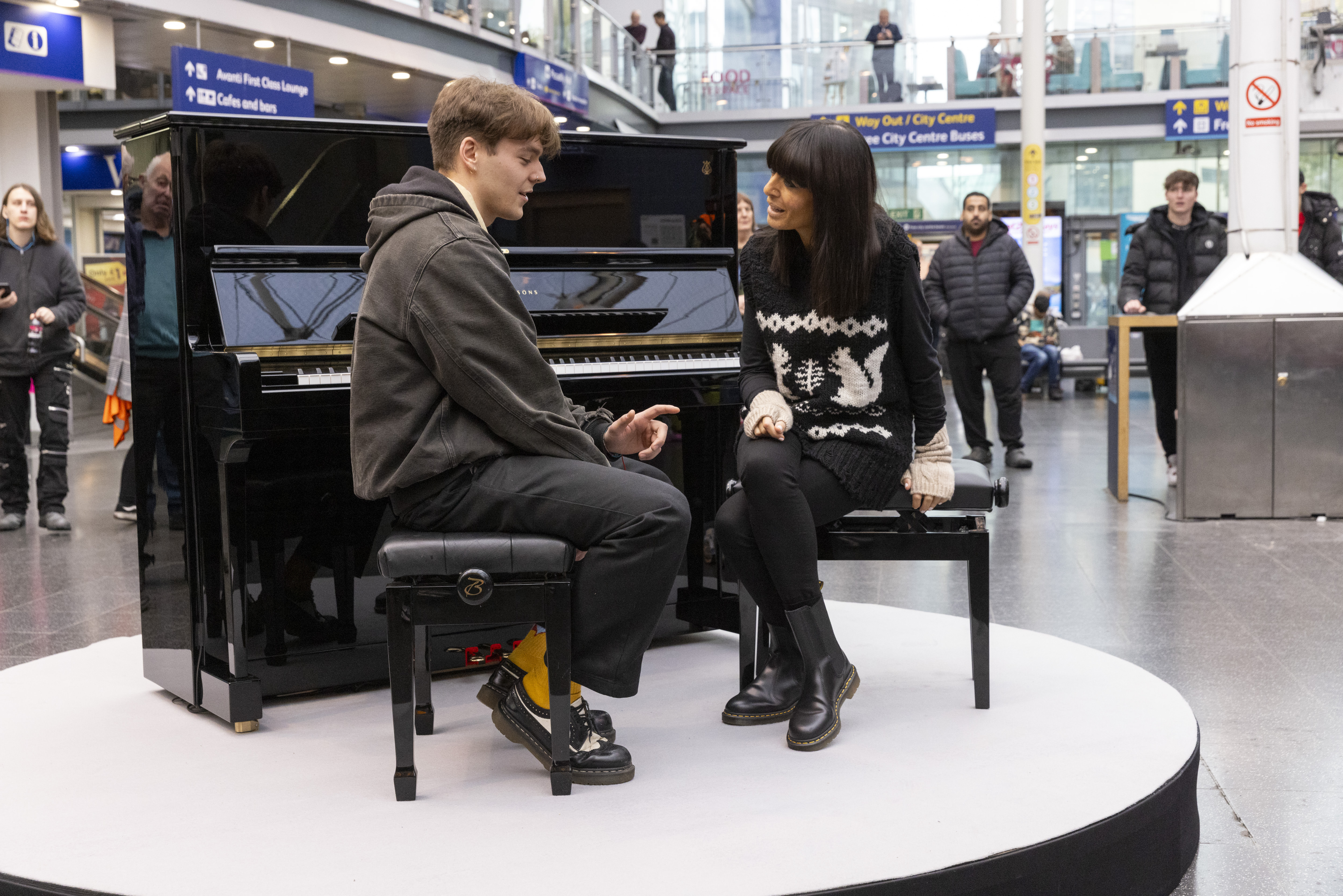 Ellis chats to Claudia before playing Chopin at Manchester Piccadilly station.