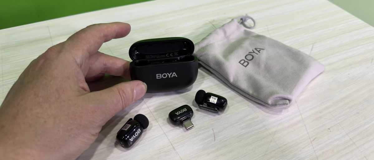 Boya Mini microphone next to their case held between two fingers