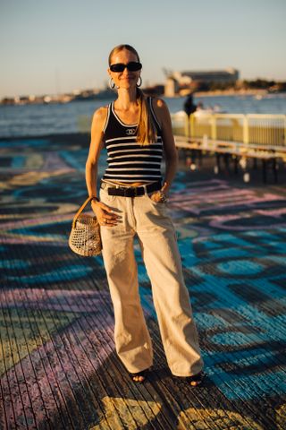 woman wearing striped tank top, khaki pants, and net bag