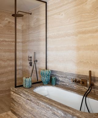 neutral bathroom with travertine walls, floor and bath surround