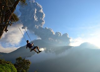 The famous "End of the World" swing in Banos, Ecuador overlooks Mt. Tungurahua. The volcano erupted while the photo was taken, and the photographer had to evacuate soon after.