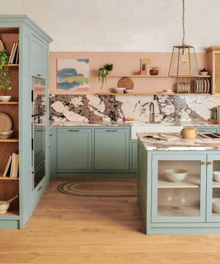 pale blue kitchen with wooden flooring and bold marble-effect quartz worktops and splashbacks