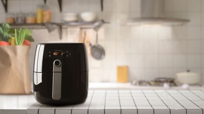 A black air fryer on a kitchen counter