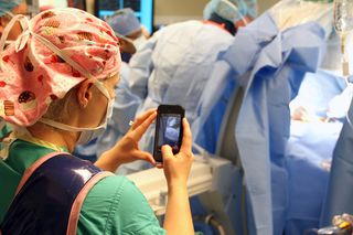 A nurse takes a photo during a recent surgery on an 8-year-old boy at Arnold Palmer Hospital for Children in Orlando, Florida. Doctors there have developed an app that allows nurses to safely and securely send texts, photos and videos from the OR directly to the smartphones of family members in an effort to keep them informed on progress during surgical procedures.