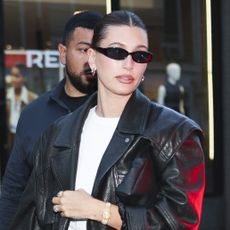  Hailey Bieber wearing a leather bomber jacket, white T-shirt, and athletic shorts in NYC